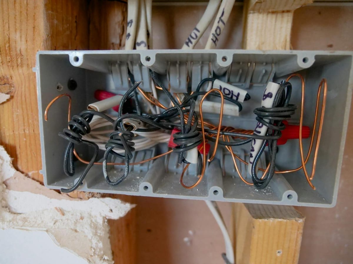 Câblage électrique vétuste avec fils emmêlés, typique des installations défaillantes trouvées lors d'un diagnostic bateau